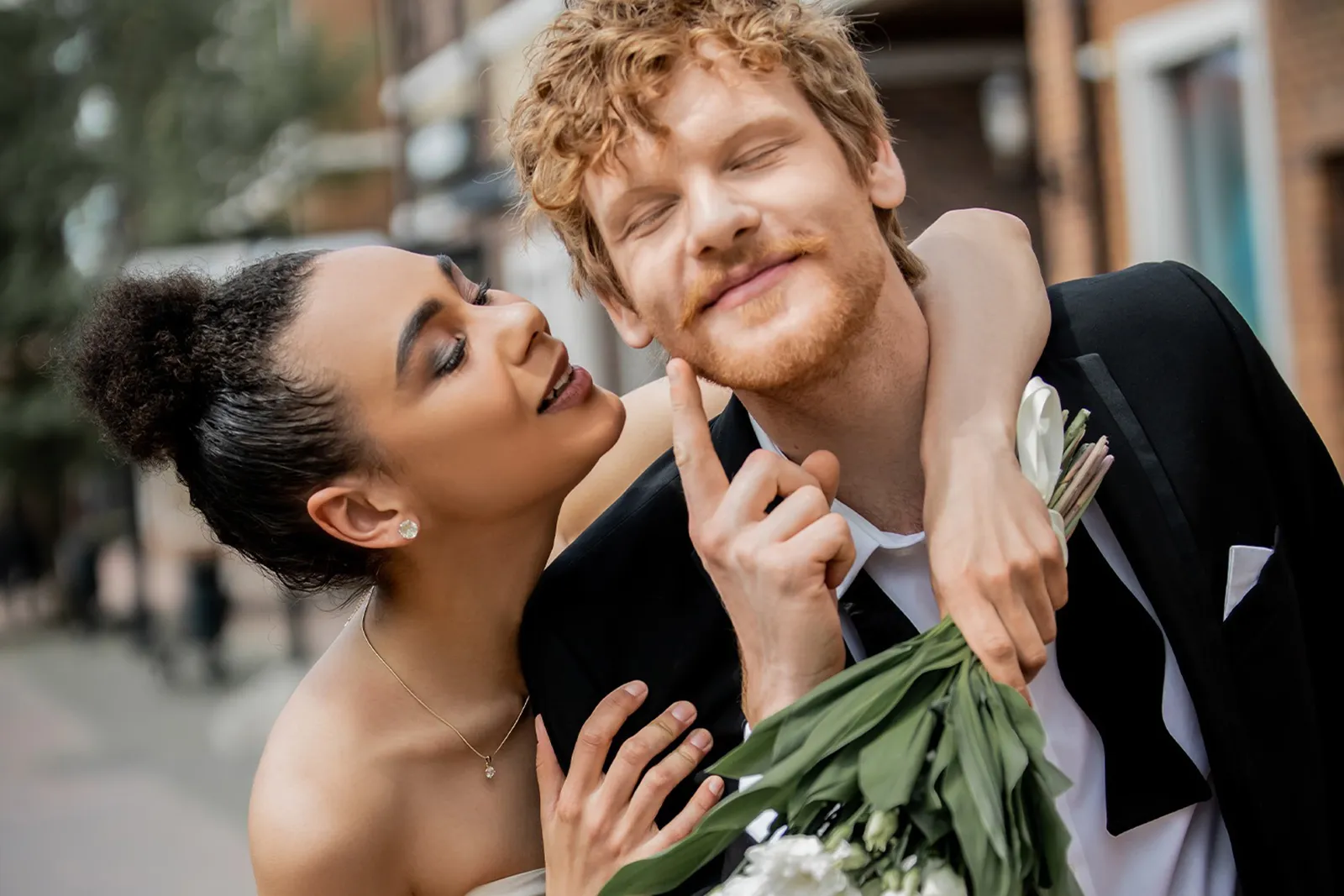 Coppia elegante durante un elopement urbano, momento spontaneo e romantico con bouquet, atmosfera intima e naturale
