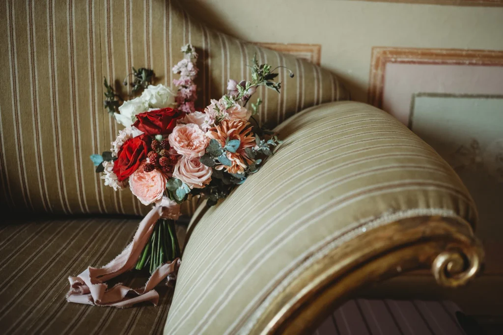 Bouquet da sposa con rose rosse e rosa, fiori cipria ed eucalipto fotografato negli interni di Villa Gaia Gandini