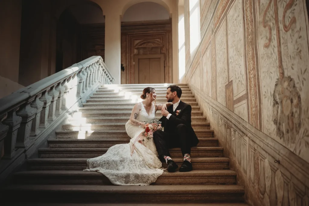 Gli sposi seduti sulla grande scala affrescata di Villa Gaia Gandini a Robecco sul Naviglio
